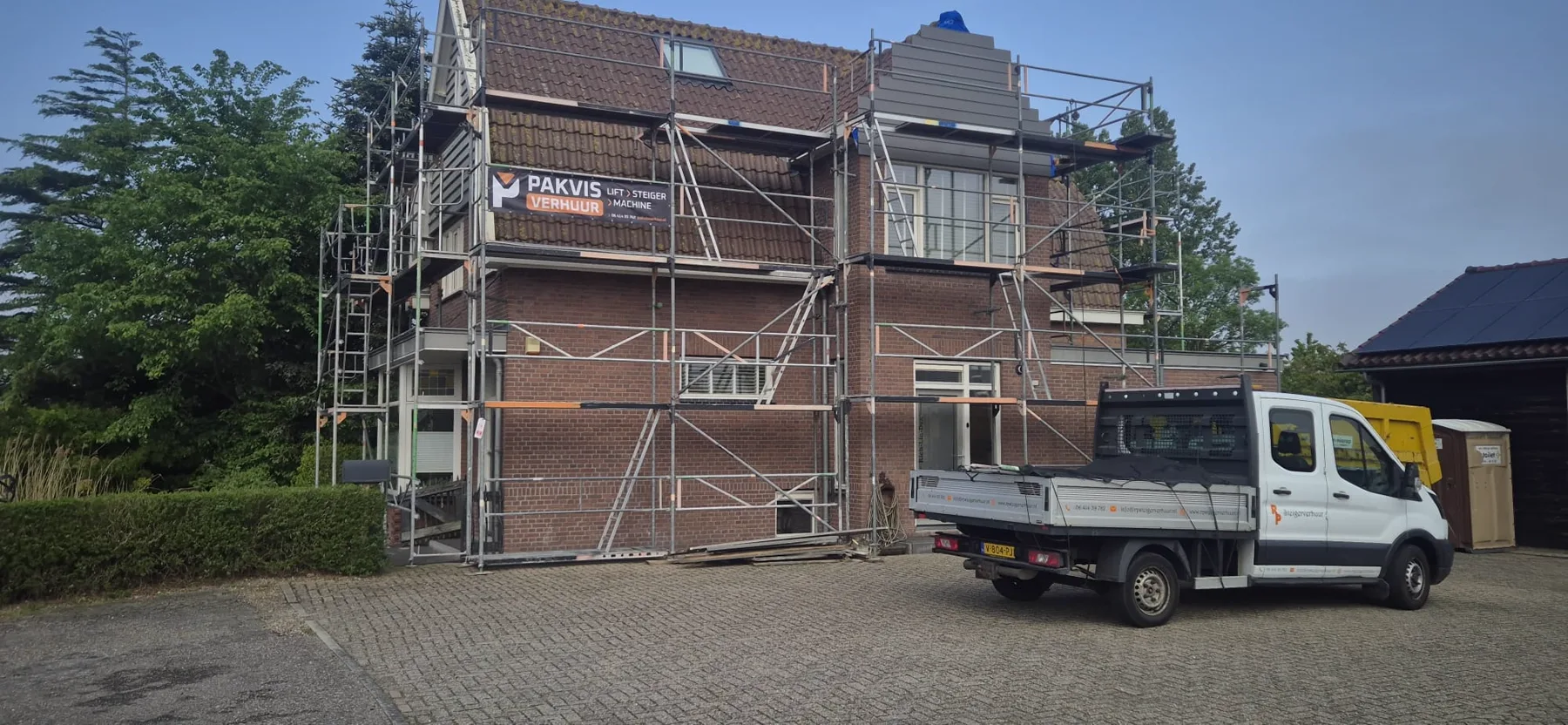 Steiger rond een vrijstaande woning met Pakvis-bedrijfswagen ernaast