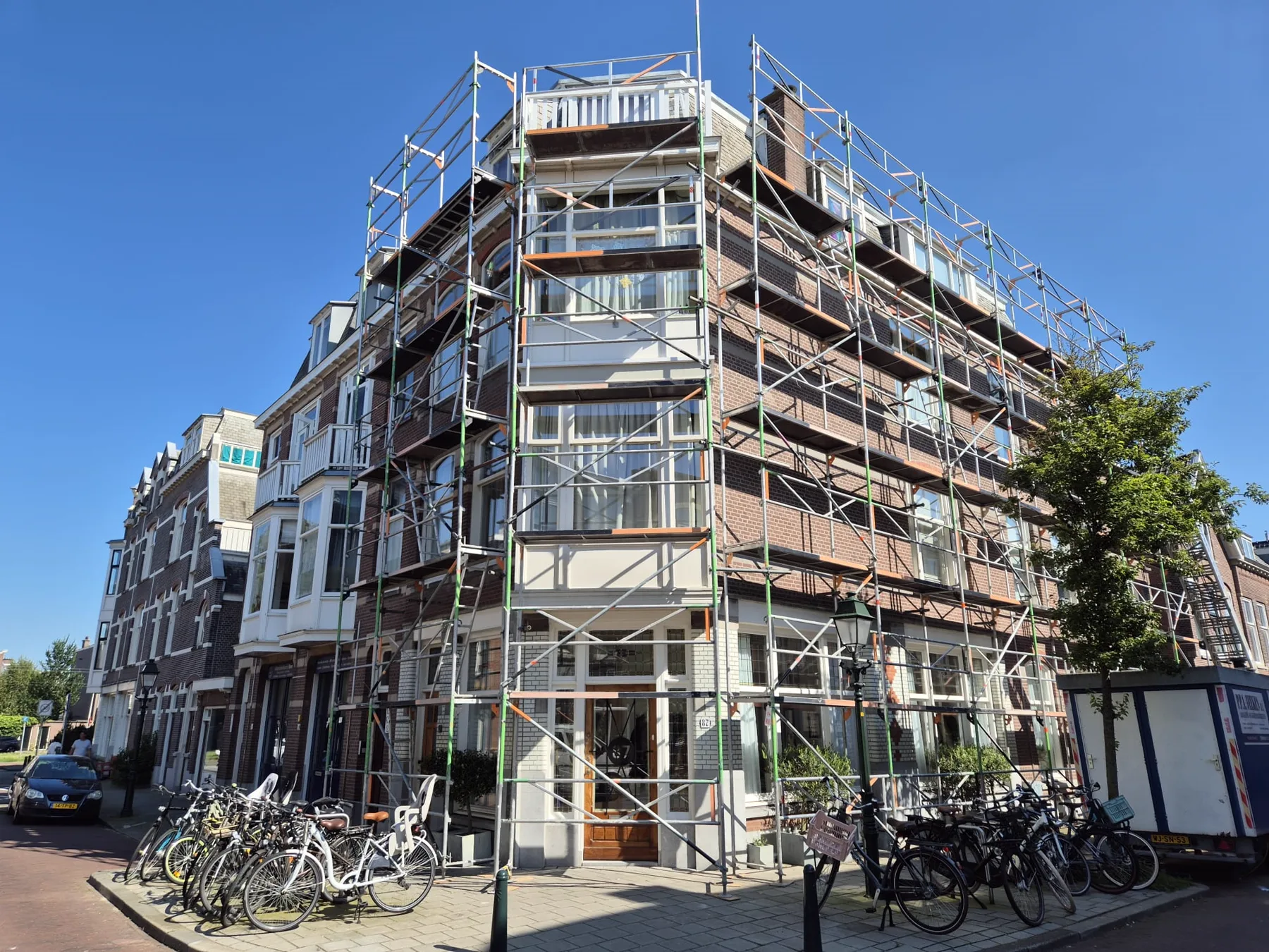 Steiger rond een hoekpand met erker en balkons